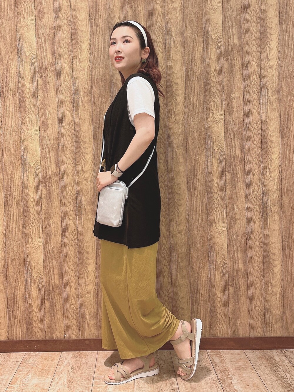 イエロー系のその他パンツ、ベージュ系のサンダル、ブラック系のベストを着用したレディースの夏コーディネートの2枚目の写真