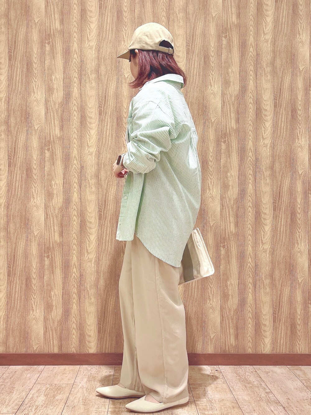 グリーン系のシャツ/ブラウス、ホワイト系のTシャツ/カットソー、グレー系のトートバッグを着用したレディースの春コーディネートの3枚目の写真