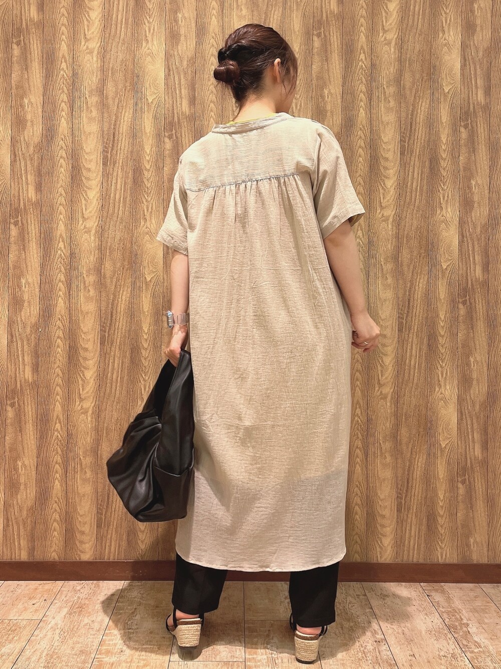 イエロー系のチュニック、ブラック系のその他パンツ、ベージュ系のシャツ/ブラウスを着用したレディースの夏コーディネートの3枚目の写真