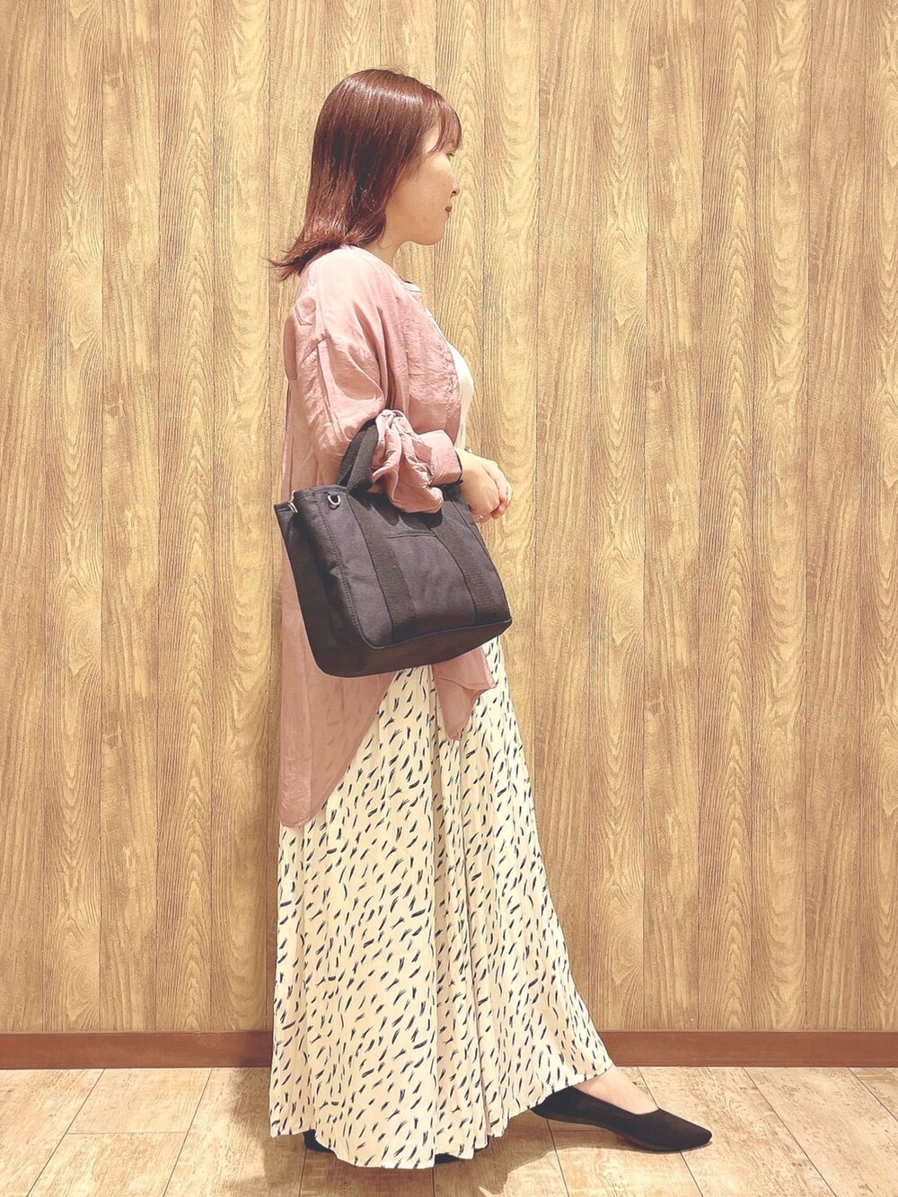 ベージュ系のスカート、ブラック系のパンプス、ホワイト系のタンクトップを着用したレディースの春コーディネートの2枚目の写真