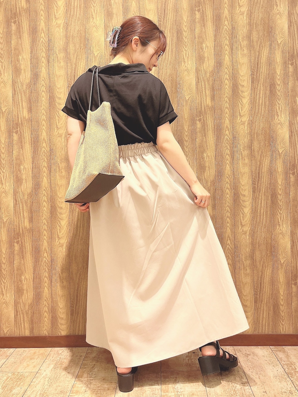 ブラック系のTシャツ/カットソー、ベージュ系のスカート、ベージュ系のトートバッグを着用したレディースの春コーディネートの3枚目の写真