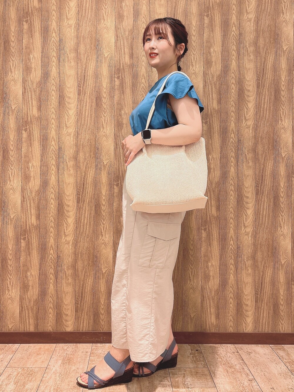 ブルー系のTシャツ/カットソー、ベージュ系のスカート、ホワイト系のトートバッグを着用したレディースの春コーディネートの2枚目の写真