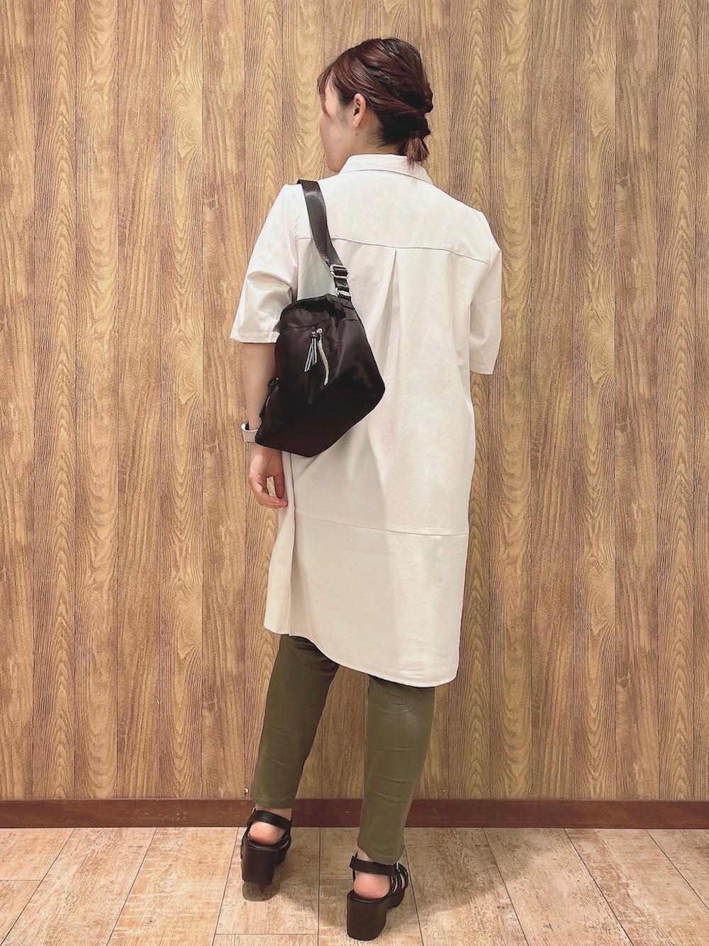 ホワイト系のチュニック、グリーン系のその他パンツ、ブラック系のショルダーバッグを着用したレディースの夏コーディネートの3枚目の写真