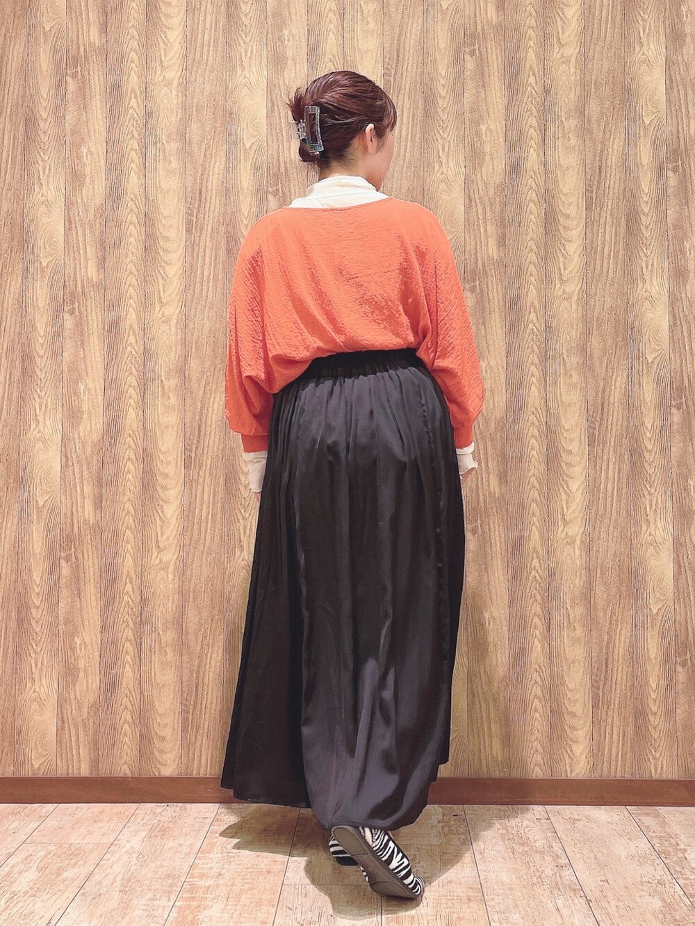 オレンジ系のシャツ/ブラウス、ベージュ系のTシャツ/カットソー、グレー系のスカートを着用したレディースの春コーディネートの3枚目の写真