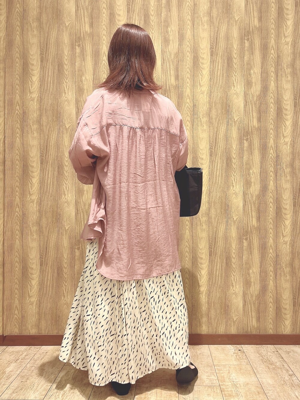 ベージュ系のスカート、ブラック系のパンプス、ホワイト系のタンクトップを着用したレディースの春コーディネートの3枚目の写真