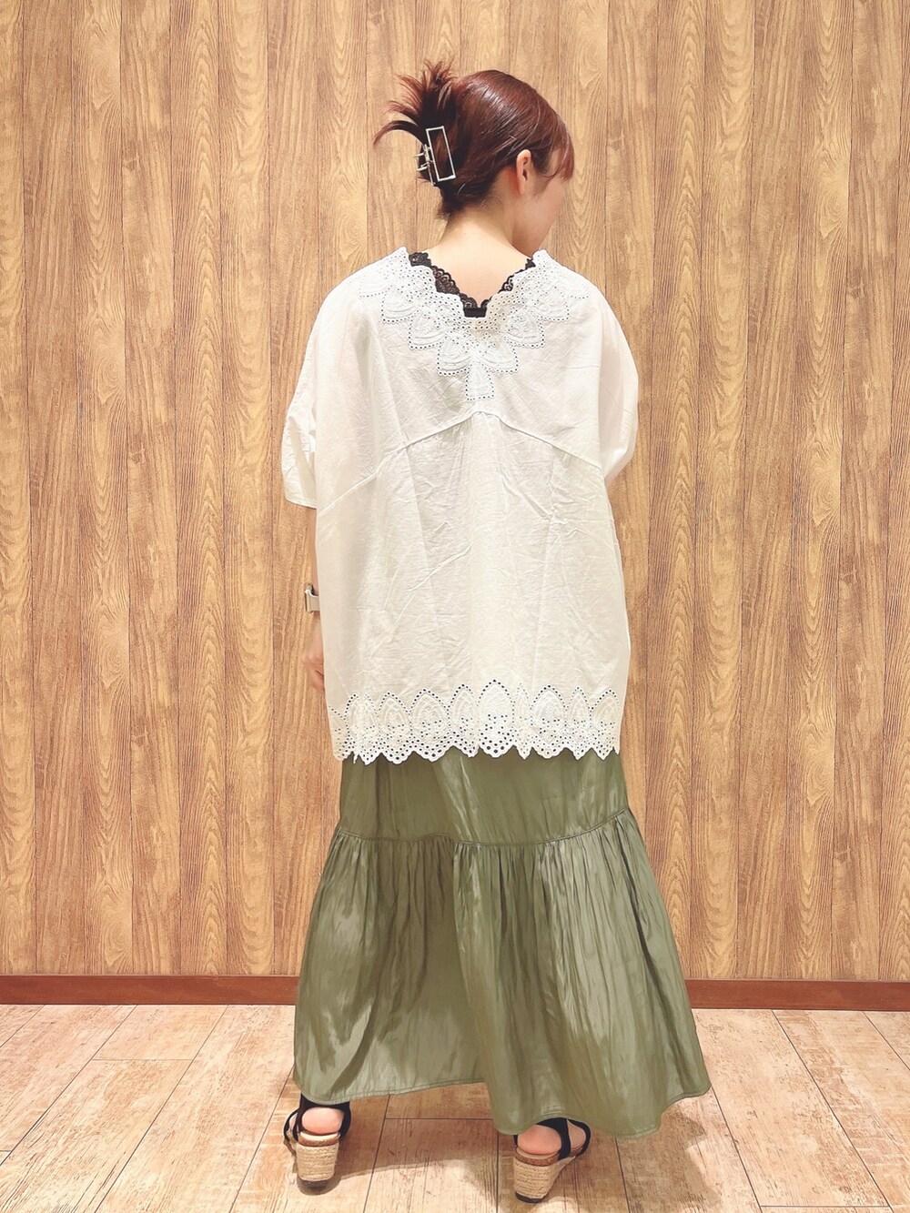 グリーン系のスカート、ブラック系のサンダル、ホワイト系のシャツ/ブラウスを着用したレディースの春コーディネートの3枚目の写真