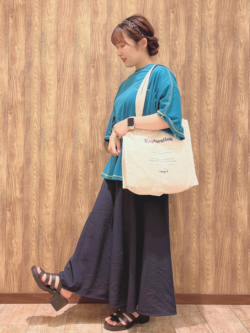 グリーン系のTシャツ/カットソー、ブルー系のスカート、ホワイト系のトートバッグを着用したレディースの春コーディネートの2枚目の写真