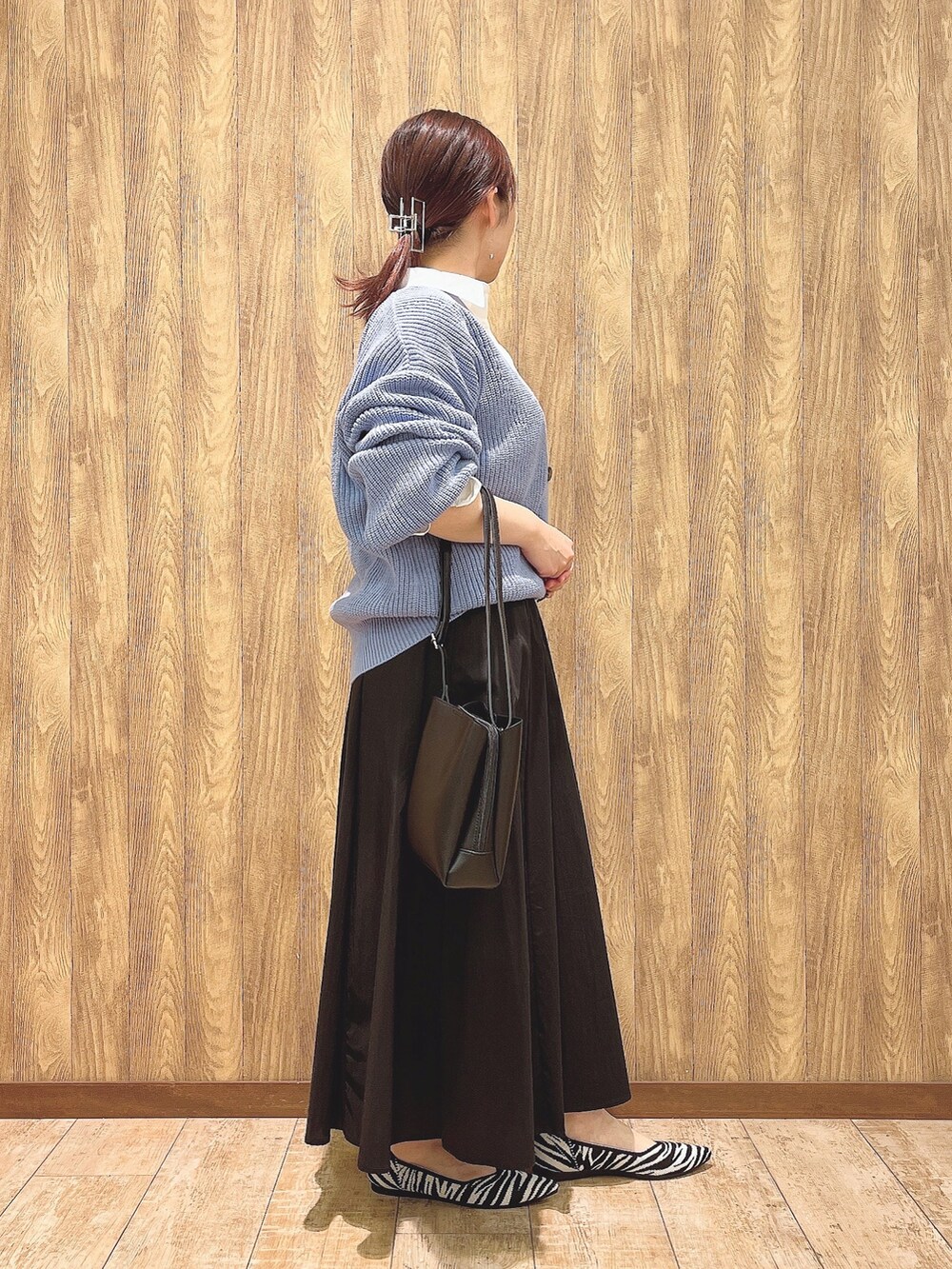 ホワイト系のシャツ/ブラウス、ブルー系のカーディガン/ボレロ、ブラック系のスカートを着用したレディースの春コーディネートの3枚目の写真