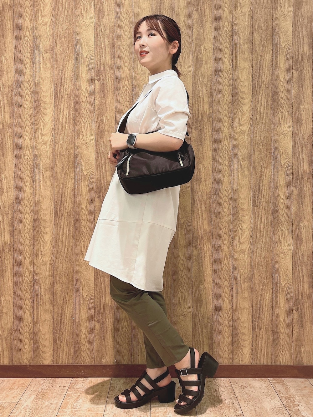 ホワイト系のチュニック、グリーン系のその他パンツ、ブラック系のショルダーバッグを着用したレディースの夏コーディネートの2枚目の写真