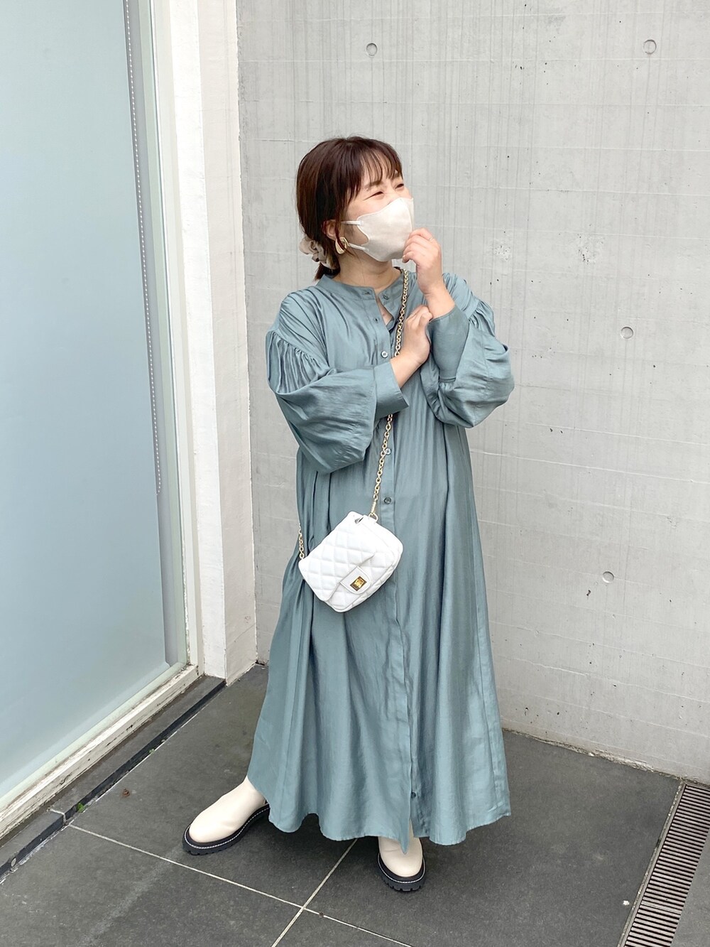 グリーン系のワンピース、ホワイト系のその他シューズ、ゴールド系のイヤリングを着用したレディースの夏コーディネートの2枚目の写真