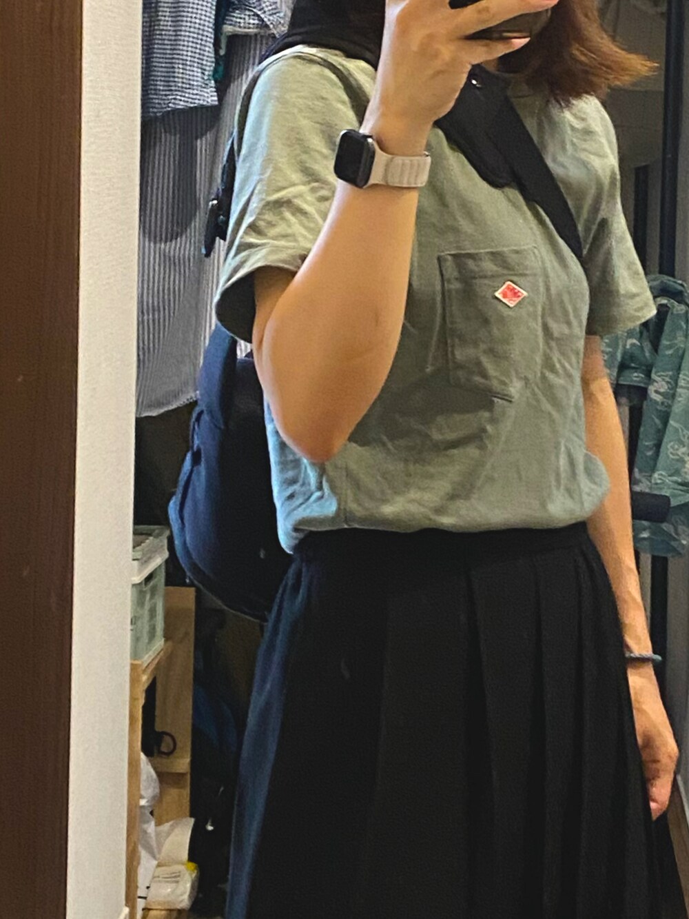 ブラック系のスカート、ベージュ系のスニーカー、グリーン系のTシャツ/カットソーを着用したレディースの夏コーディネートの2枚目の写真