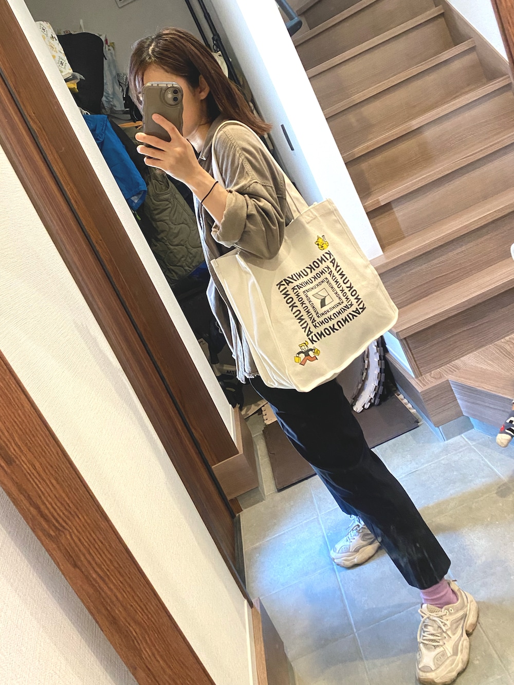 ブラック系のパンツ、ベージュ系のスニーカー、ブラック系のトップスを着用したレディースの春コーディネートの2枚目の写真