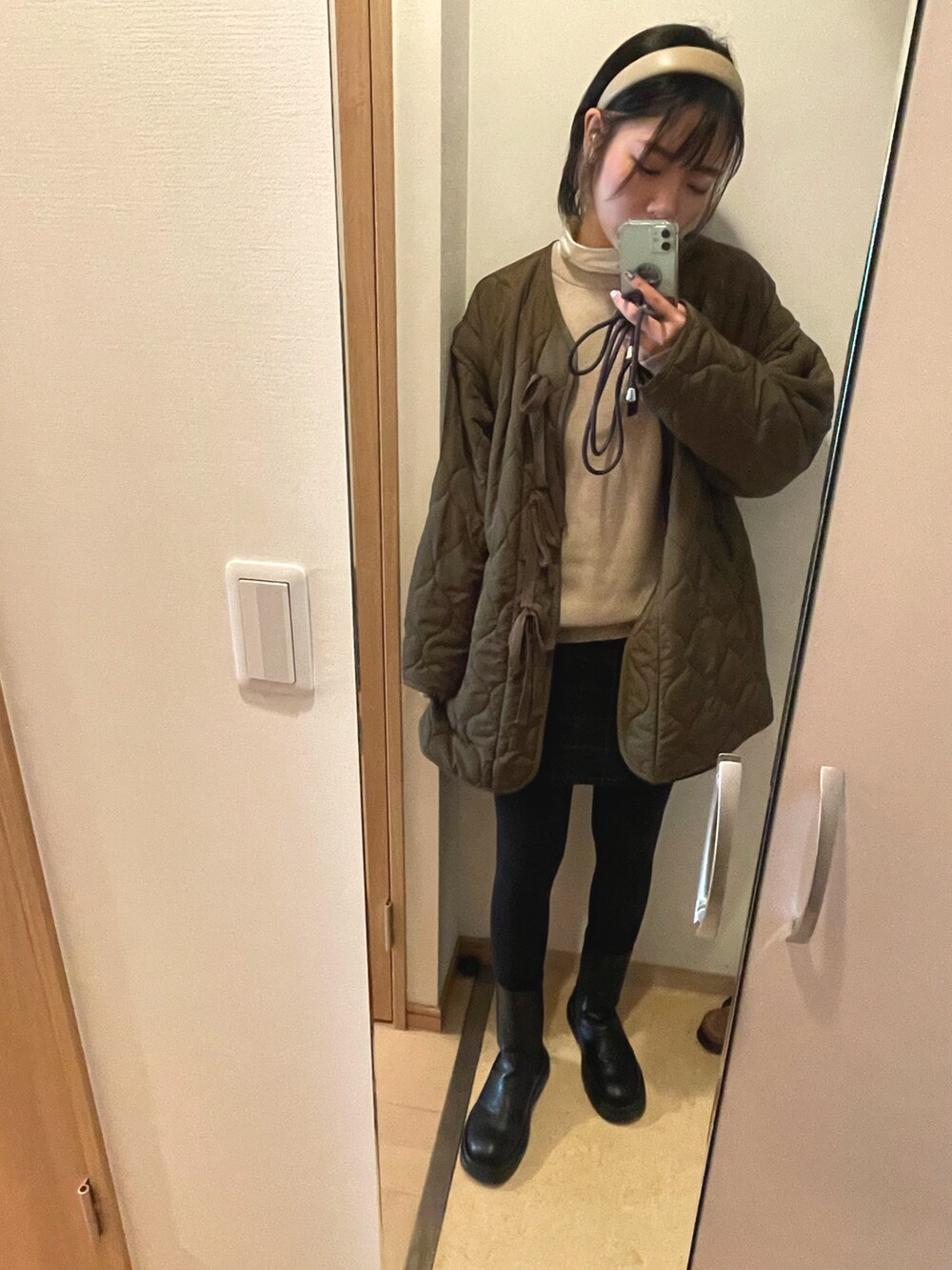 ベージュ系のニット/セーター、ホワイト系のその他トップス、ブラック系のスカートを着用したレディースの冬コーディネートの2枚目の写真