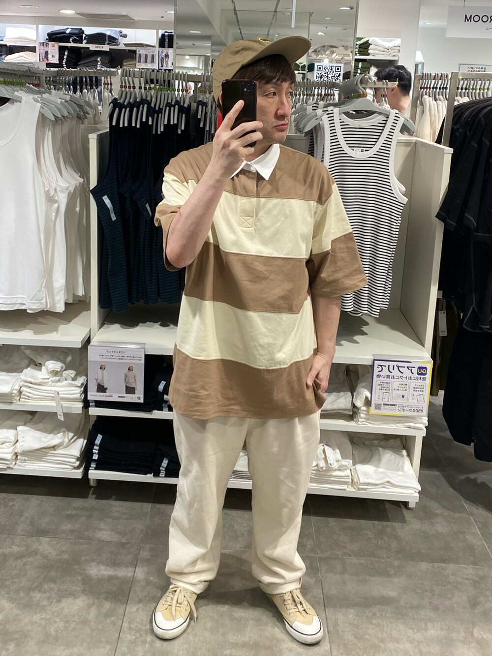 ベージュ系のトップス、ホワイト系のスラックス、ベージュ系のスニーカーを着用したメンズの夏コーディネートの2枚目の写真