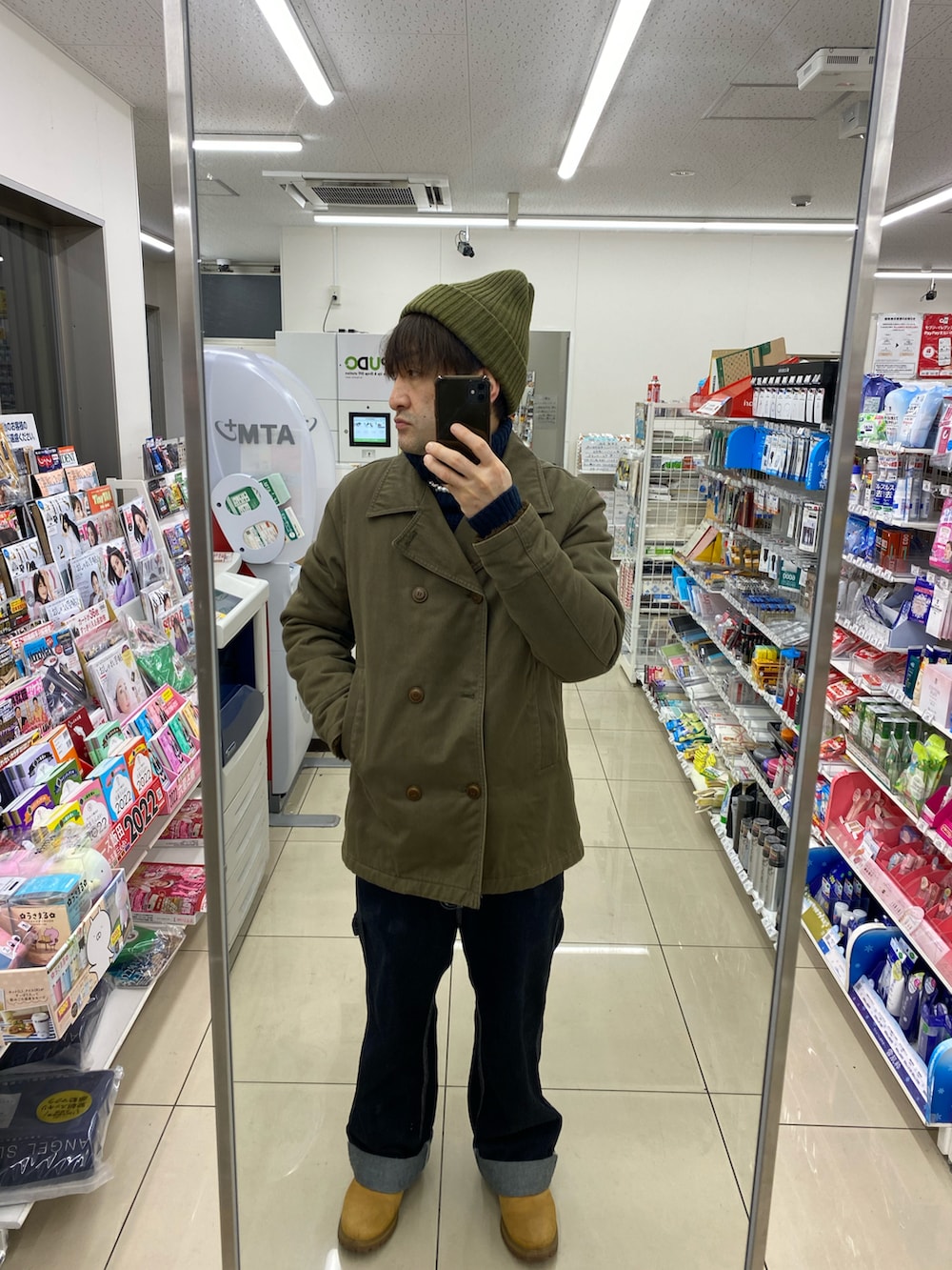 ブルー系のカーゴパンツ、ベージュ系のブーツ、グリーン系のピーコートを着用したメンズの冬コーディネートの2枚目の写真