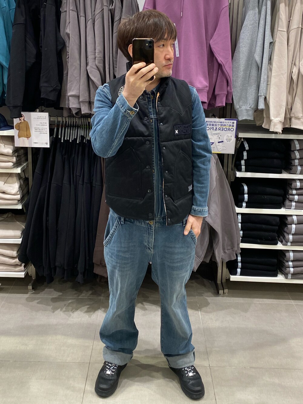 ブルー系のつなぎ/オールインワン、ブラック系のスニーカー、ブラック系のダウンベストを着用したメンズの秋コーディネートの5枚目の写真