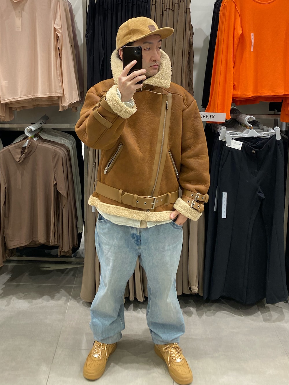 ブルー系のシャツ/ブラウス、ブラウン系のムートンコート、ブルー系のデニムパンツを着用したメンズの冬コーディネートの5枚目の写真