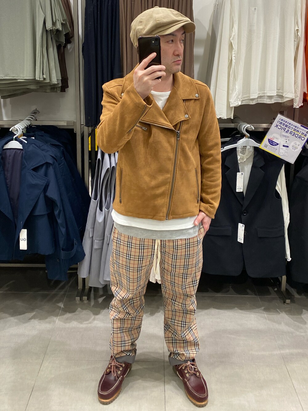 ブラウン系のライダースジャケット、ベージュ系のパンツ、ブラウン系のモカシン/デッキシューズを着用したメンズの春コーディネートの2枚目の写真