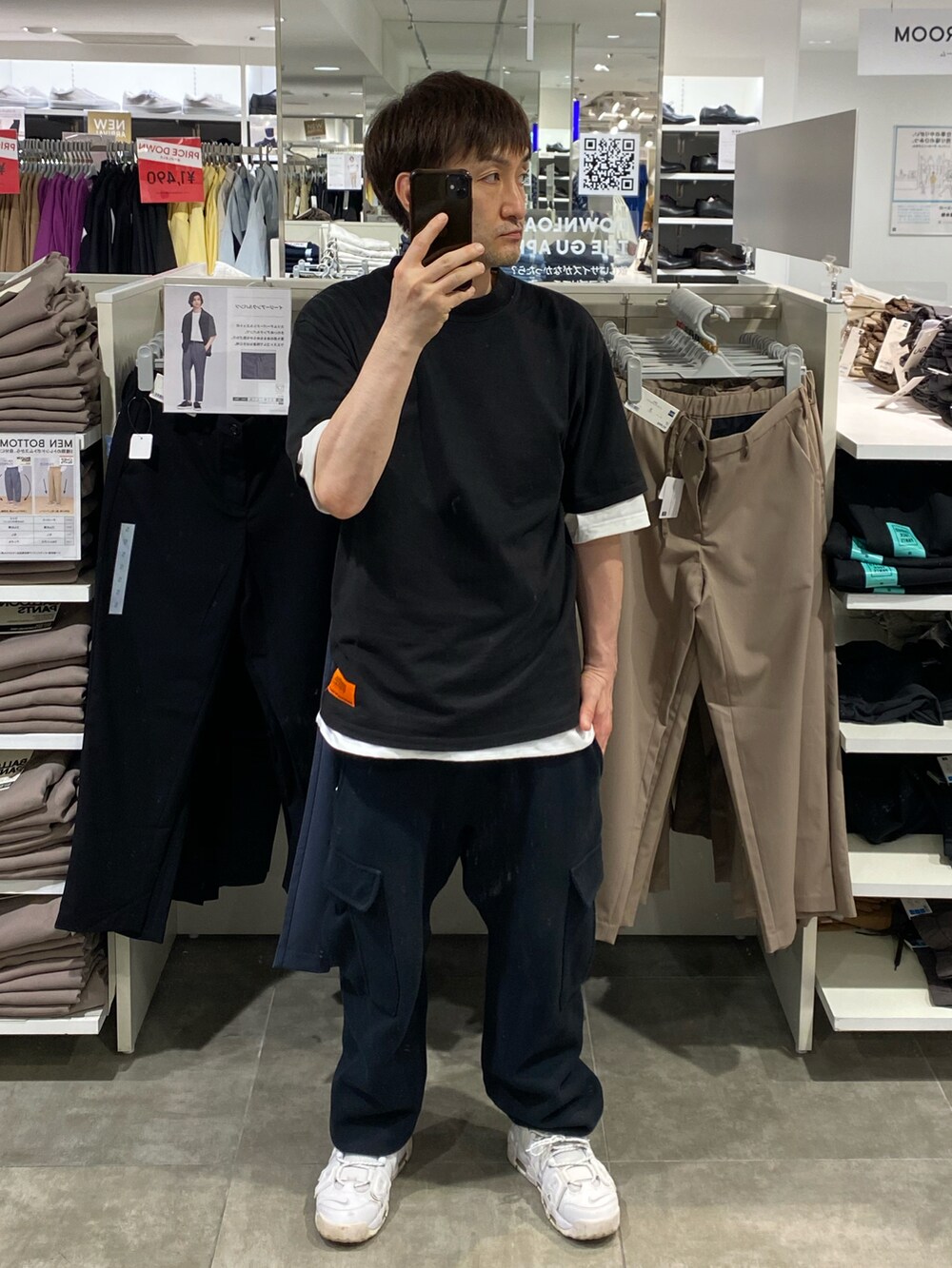 ブラック系のTシャツ/カットソー、ブラック系のカーゴパンツ、ホワイト系のスニーカーを着用したメンズの夏コーディネートの3枚目の写真