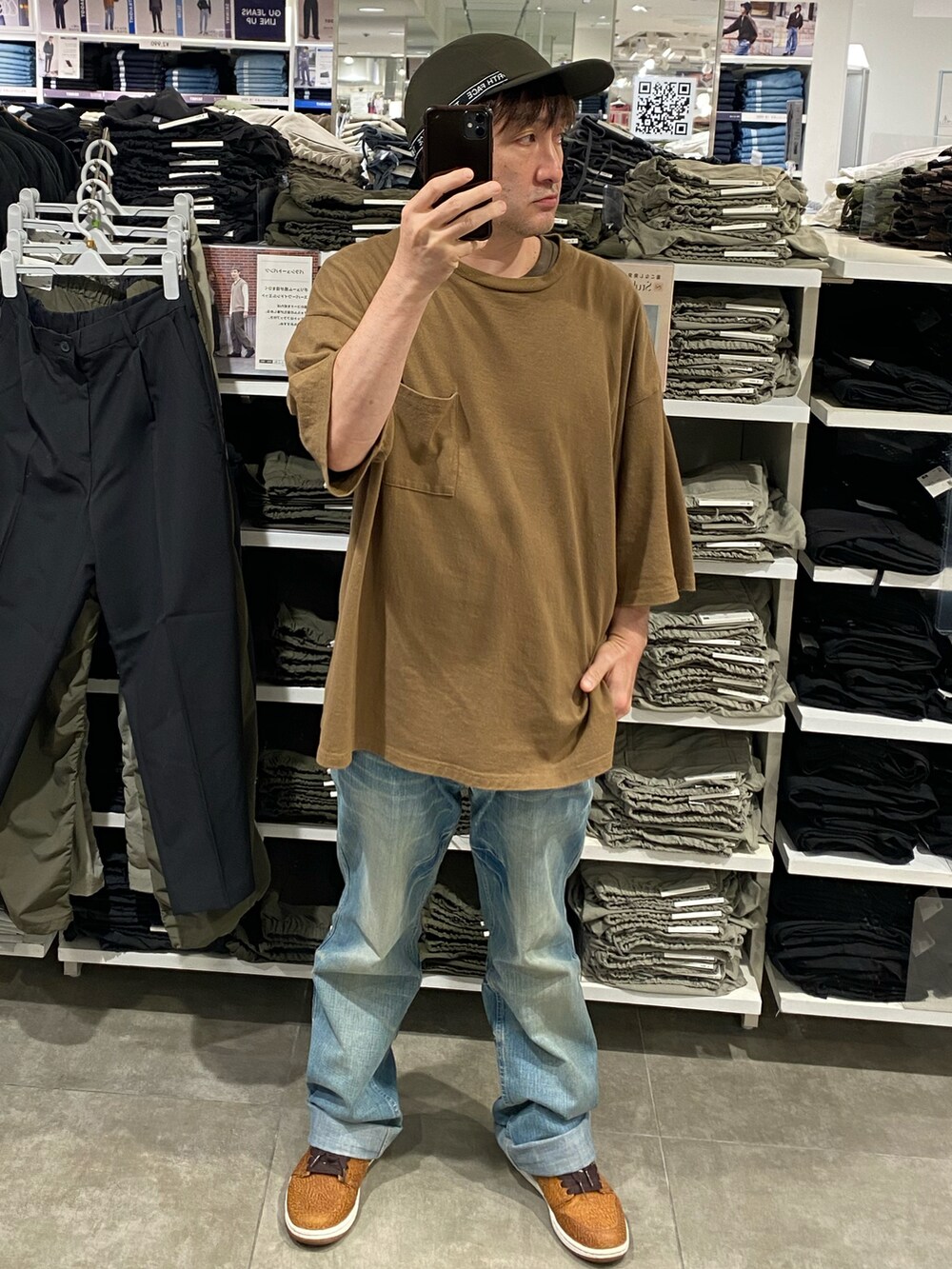 ブラウン系のTシャツ/カットソー、ブルー系のデニムパンツ、ブラウン系のスニーカーを着用したメンズの秋コーディネートの2枚目の写真