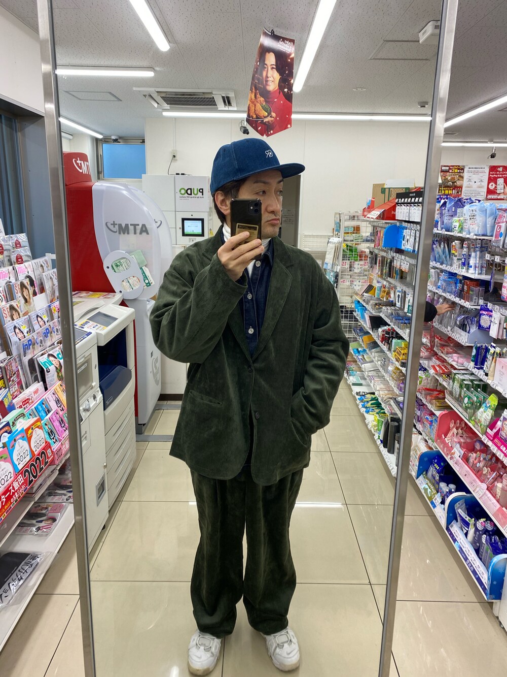 グリーン系のテーラードジャケット、ホワイト系のスニーカー、ブルー系のシャツ/ブラウスを着用したメンズの冬コーディネートの2枚目の写真