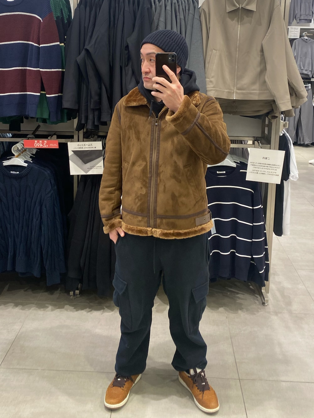 ブラック系のカーゴパンツ、ブラウン系のミリタリージャケット、ブラウン系のスニーカーを着用したメンズの冬コーディネートの2枚目の写真