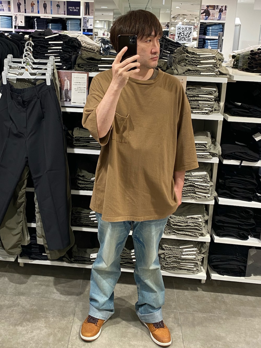 ブラウン系のTシャツ/カットソー、ブルー系のデニムパンツ、ブラウン系のスニーカーを着用したメンズの秋コーディネートの3枚目の写真