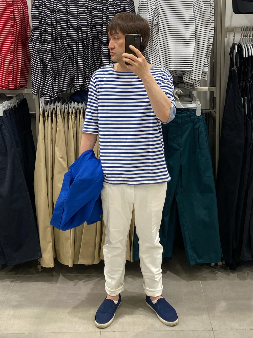 ブルー系のステンカラーコート、ブルー系のステンカラーコート、ホワイト系のデニムパンツを着用したメンズの春コーディネートの2枚目の写真