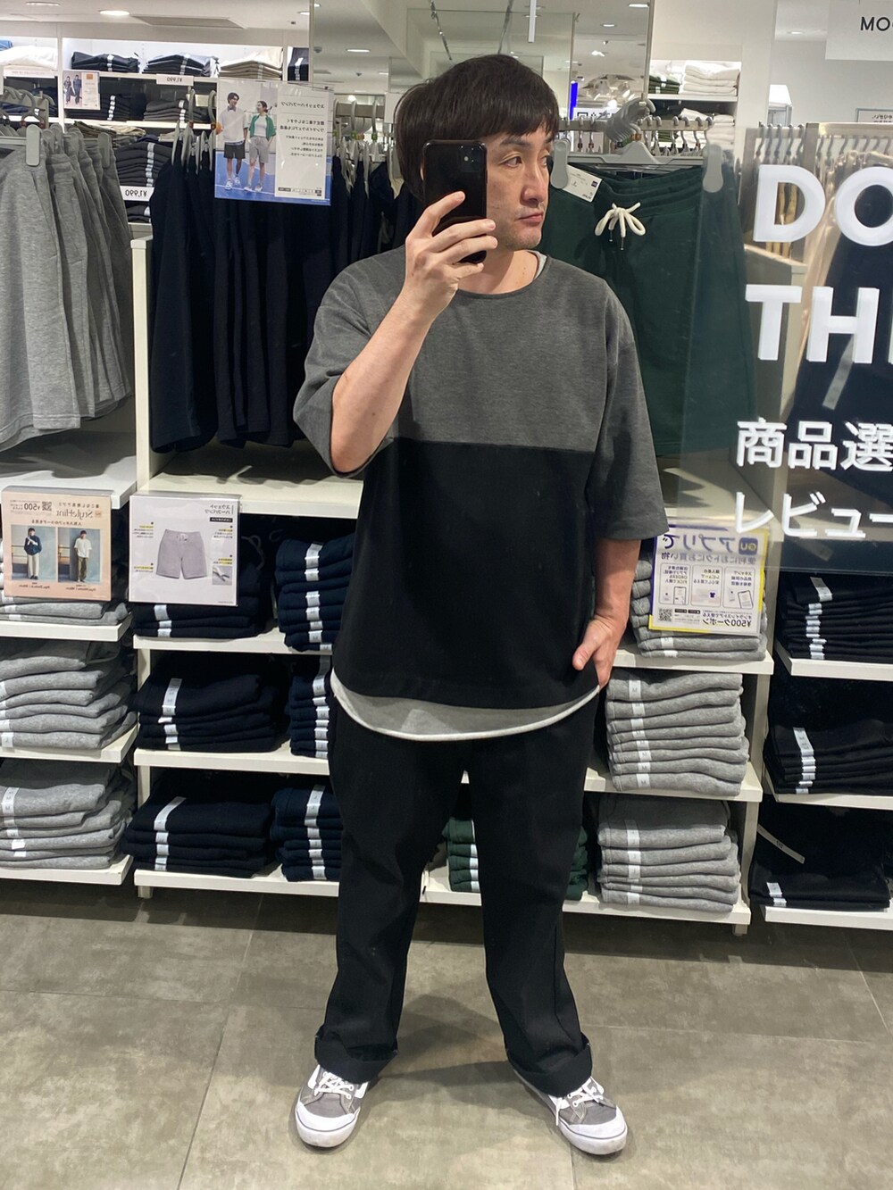 ブラック系のTシャツ/カットソー、ブラック系のチノパンツ、グレー系のスニーカーを着用したメンズの夏コーディネートの3枚目の写真