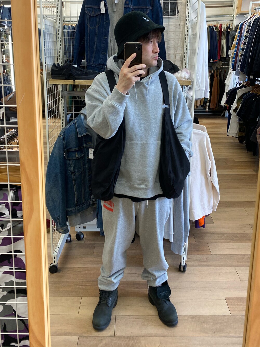 グレー系のパーカー、ブラック系のショルダーバッグ、グレー系のスウェットパンツを着用したメンズの春コーディネートの2枚目の写真