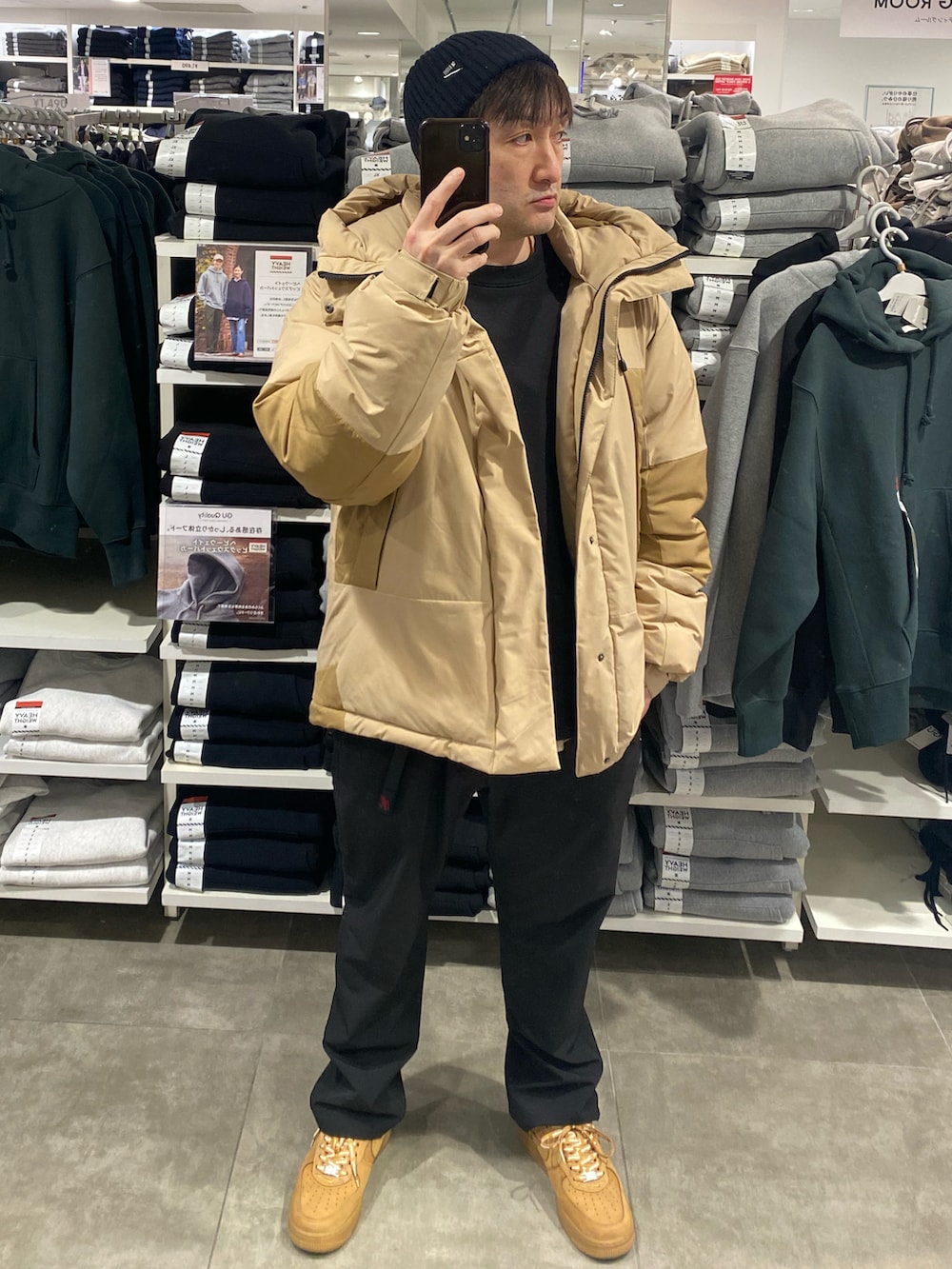 ベージュ系のダウンジャケット/コート、ブラック系のその他パンツ、ブラウン系のスニーカーを着用したメンズの冬コーディネートの4枚目の写真