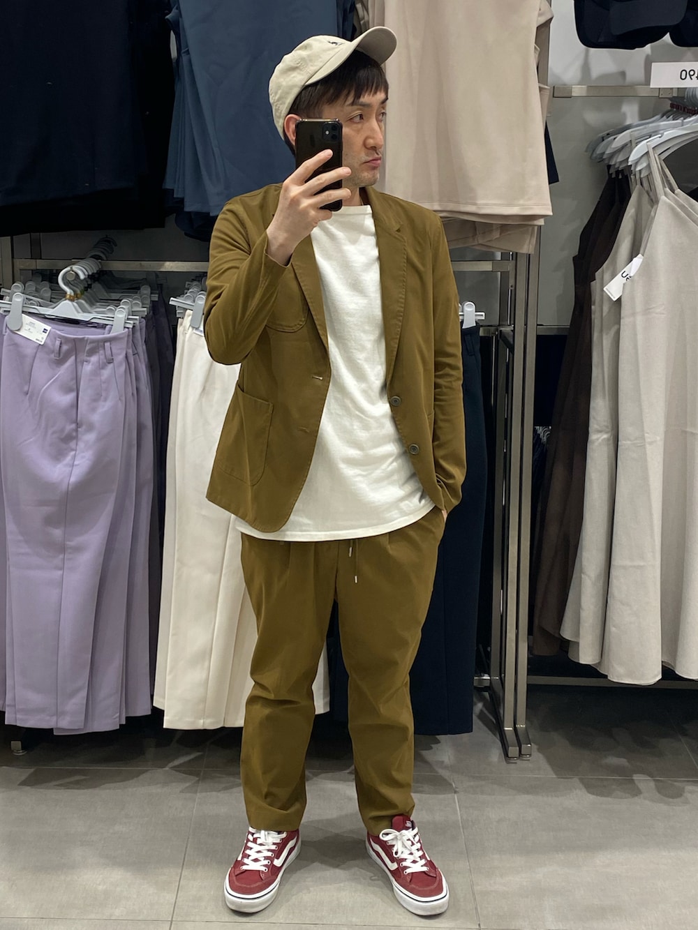 ブラウン系のテーラードジャケット、ブラウン系のスラックス、レッド系のスニーカーを着用したメンズの夏コーディネートの2枚目の写真