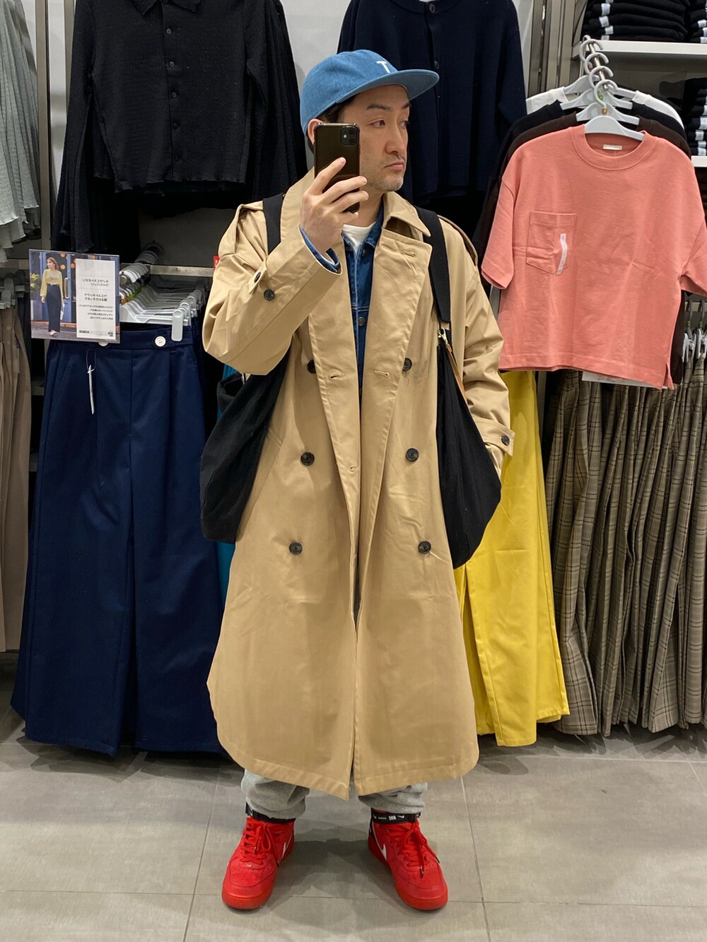 ベージュ系のトレンチコート、グレー系のスウェットパンツ、レッド系のスニーカーを着用したメンズの春コーディネートの3枚目の写真