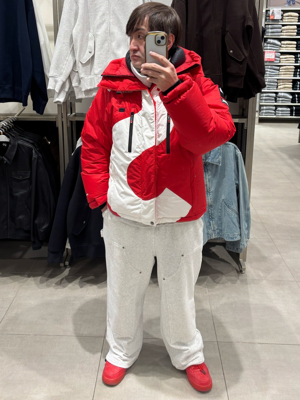 グレー系のスウェットパンツ、レッド系のスニーカー、レッド系のダウンジャケット/コートを着用したメンズの冬コーディネートの2枚目の写真