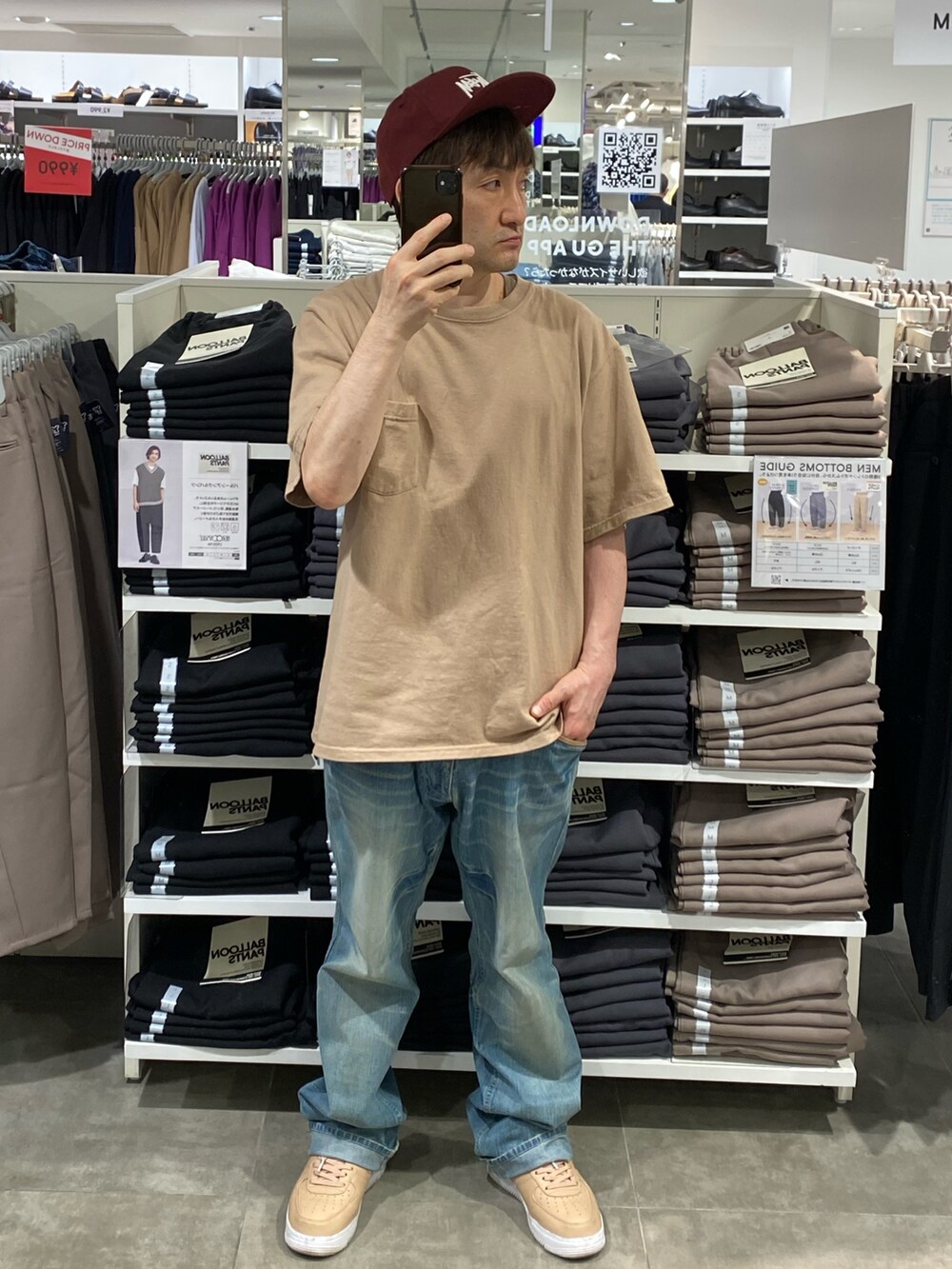 ベージュ系のTシャツ/カットソー、ブルー系のデニムパンツ、ベージュ系のスニーカーを着用したメンズの秋コーディネートの2枚目の写真