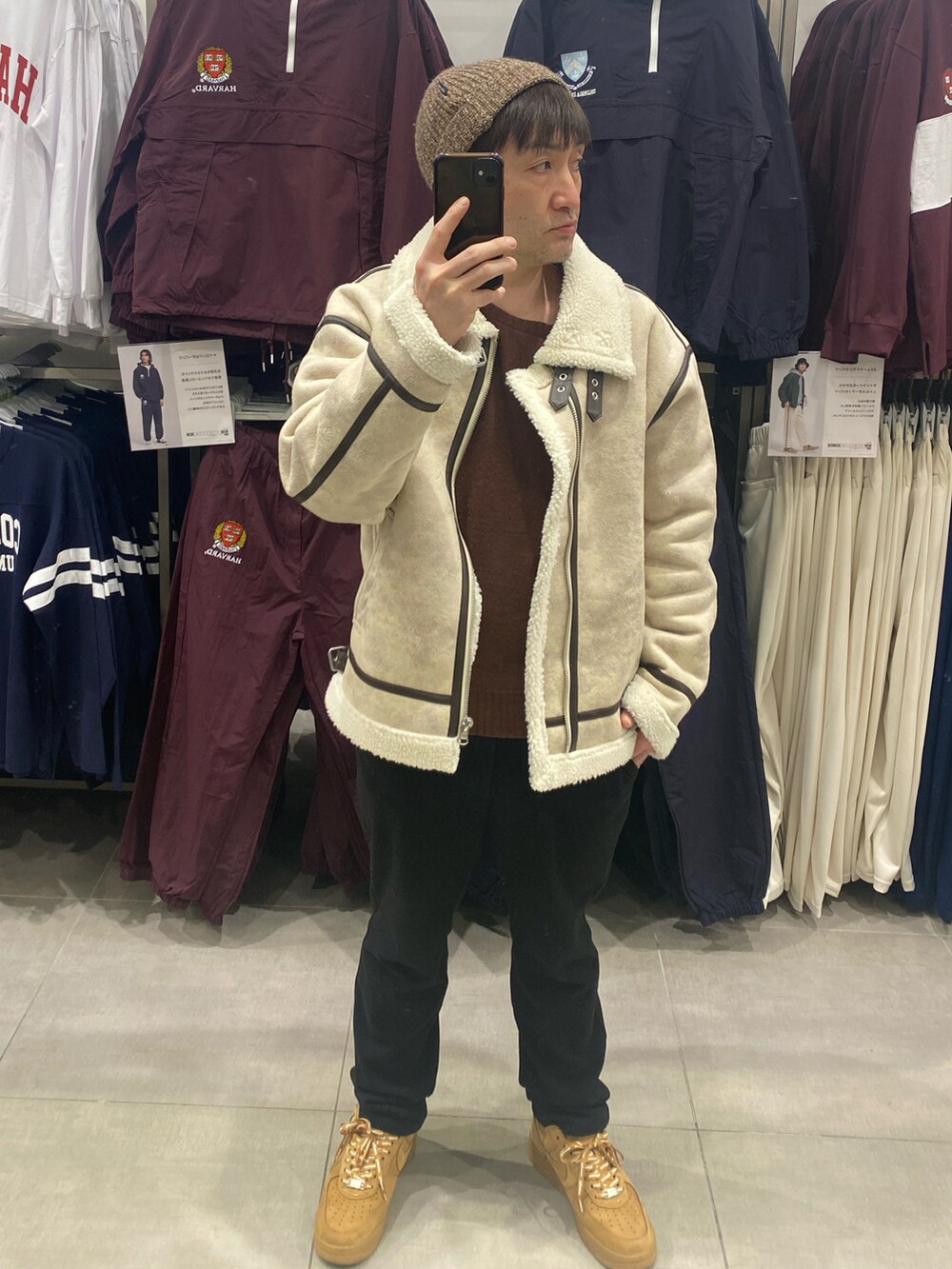 ホワイト系のブルゾン、ブラック系のその他パンツ、ブラウン系のスニーカーを着用したメンズの冬コーディネートの2枚目の写真