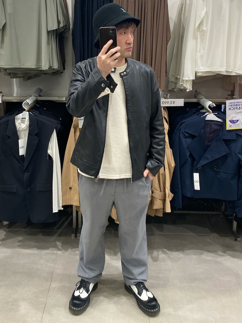 ホワイト系のニット/セーター、グレー系のスラックス、ブラック系のドレスシューズを着用したメンズの春コーディネートの2枚目の写真