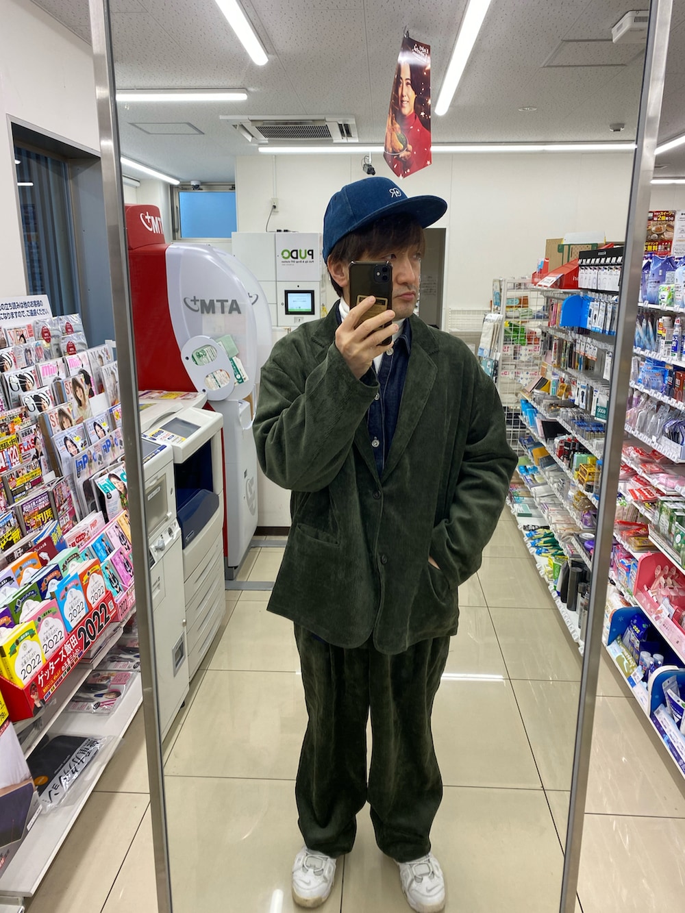 グリーン系のテーラードジャケット、ホワイト系のスニーカー、ブルー系のシャツ/ブラウスを着用したメンズの冬コーディネートの3枚目の写真