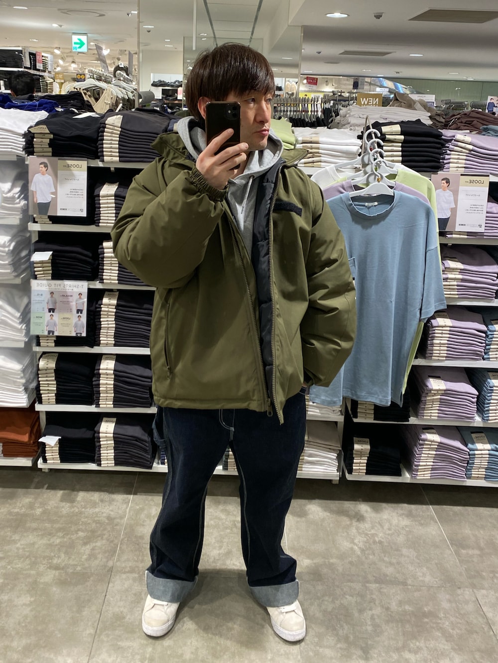 ホワイト系のスニーカー、ブルー系のカーゴパンツ、グリーン系のブルゾンを着用したメンズの冬コーディネートの2枚目の写真