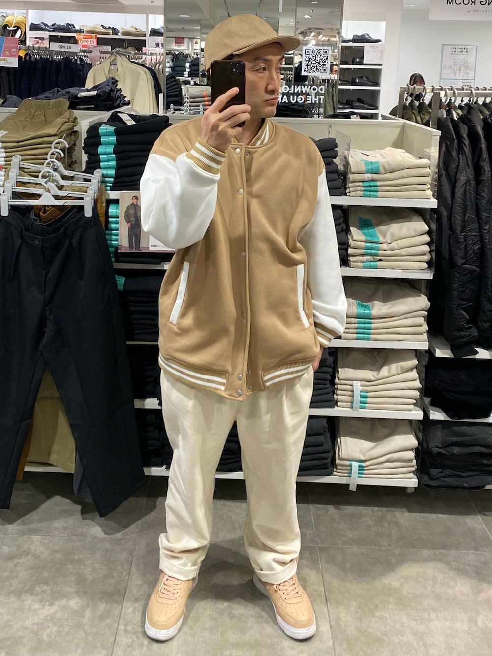 ベージュ系のスタジャン、ホワイト系のスラックス、ベージュ系のスニーカーを着用したメンズの秋コーディネートの4枚目の写真