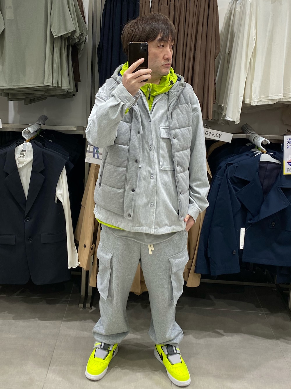 グレー系のダウンベスト、グレー系のカバーオール、グレー系のスウェットパンツを着用したメンズの春コーディネートの3枚目の写真