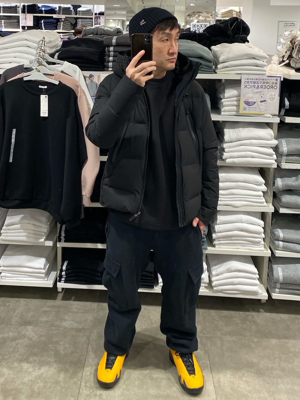 ブラック系のダウンジャケット/コート、ブラック系のスウェット、ブラック系のカーゴパンツを着用したメンズの冬コーディネートの2枚目の写真