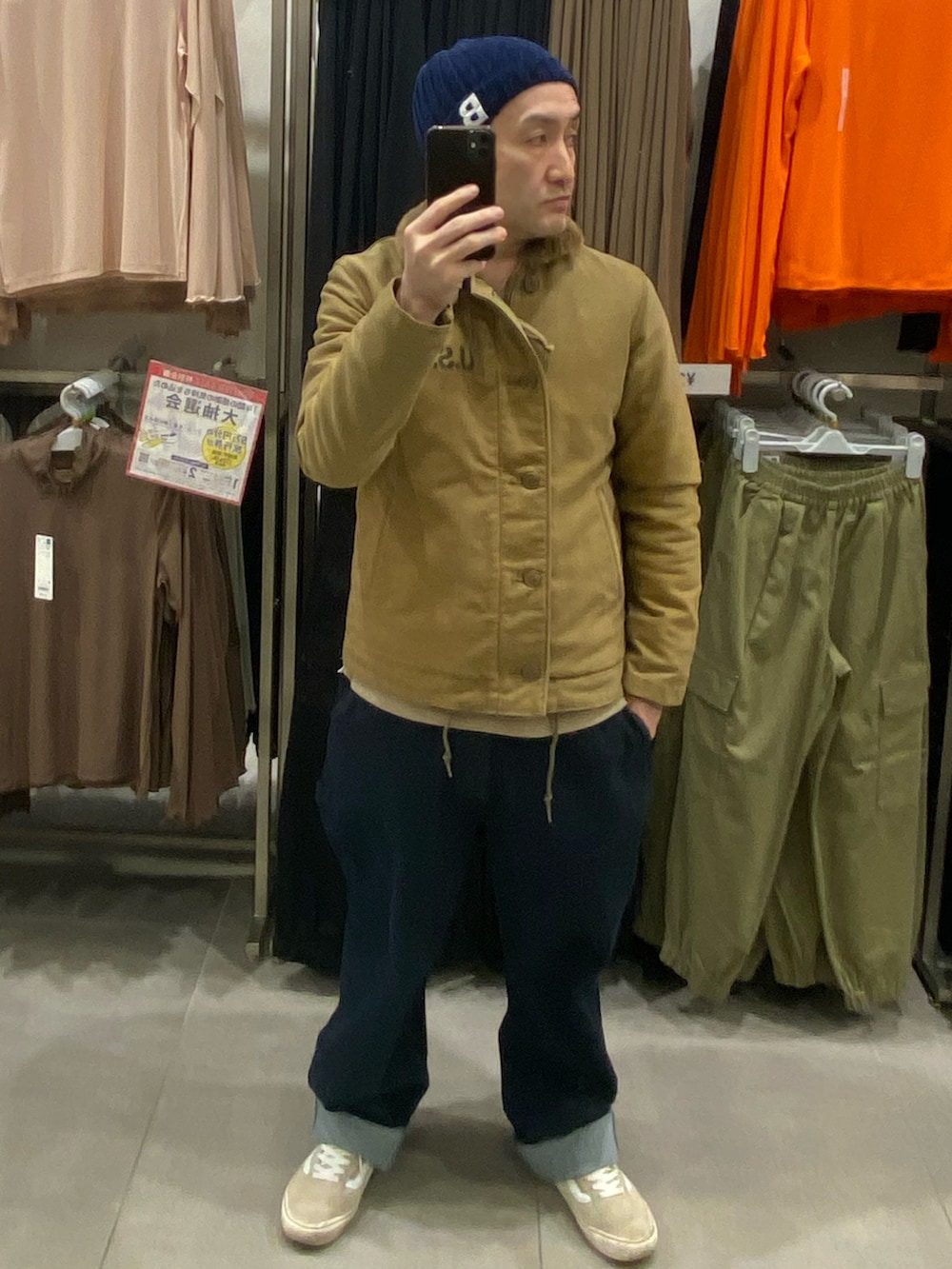 ブラウン系のスウェット、その他のミリタリージャケット、ブルー系のデニムパンツを着用したメンズの冬コーディネートの4枚目の写真