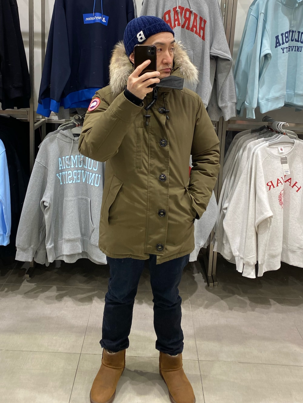 グリーン系のダウンジャケット/コート、ブルー系のデニムパンツ、ブラウン系のブーツを着用したメンズの冬コーディネートの5枚目の写真