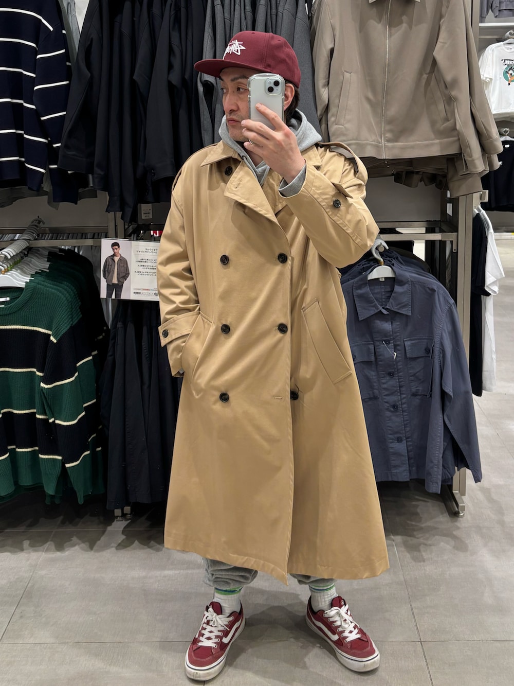 ベージュ系のトレンチコート、グレー系のパーカー、グレー系のスウェットパンツを着用したメンズの春コーディネートの3枚目の写真