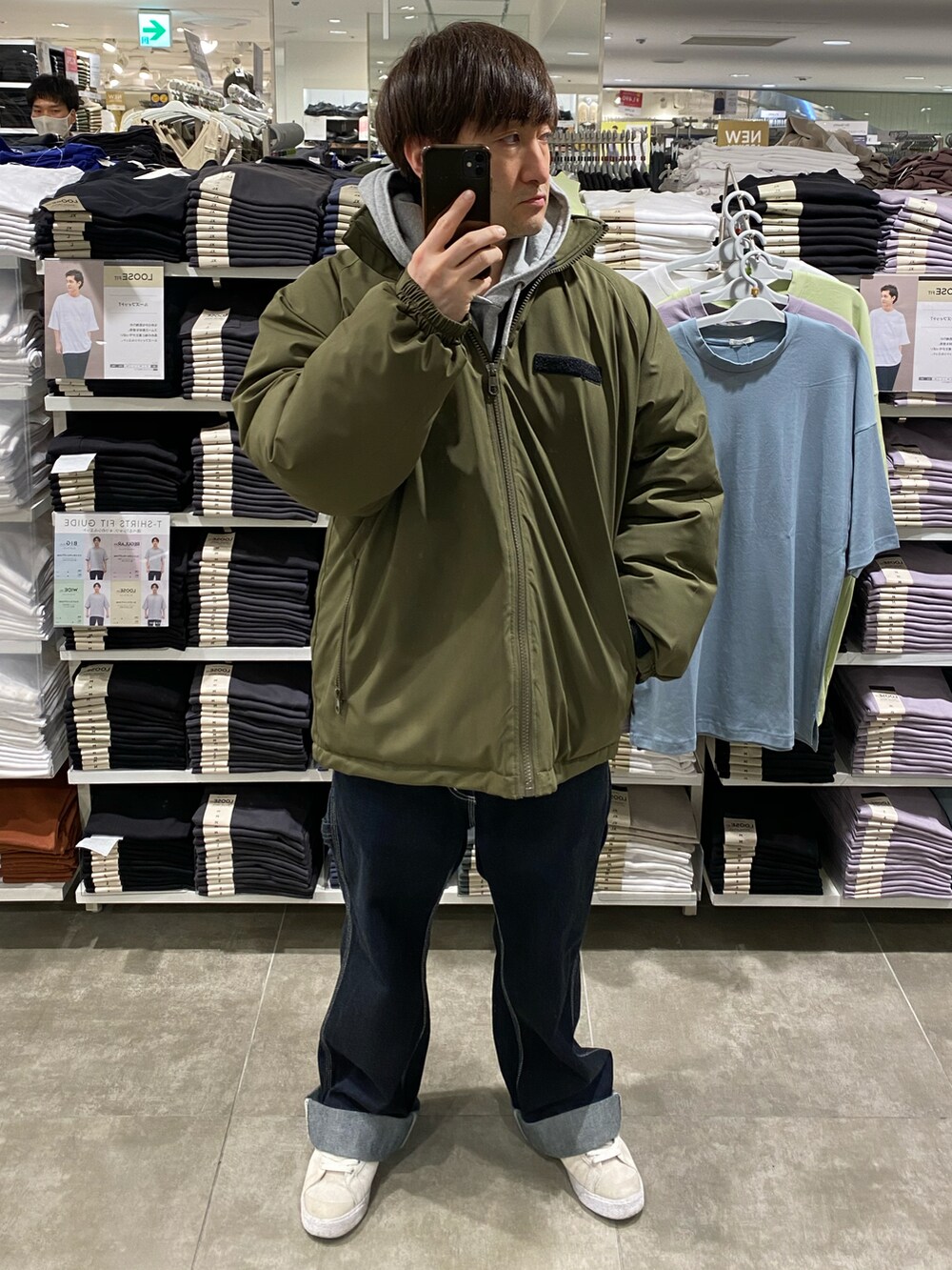 ホワイト系のスニーカー、ブルー系のカーゴパンツ、グリーン系のブルゾンを着用したメンズの冬コーディネートの4枚目の写真