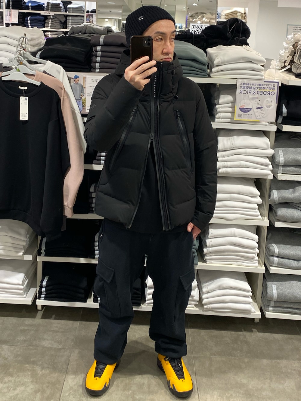 ブラック系のダウンジャケット/コート、ブラック系のスウェット、ブラック系のカーゴパンツを着用したメンズの冬コーディネートの5枚目の写真