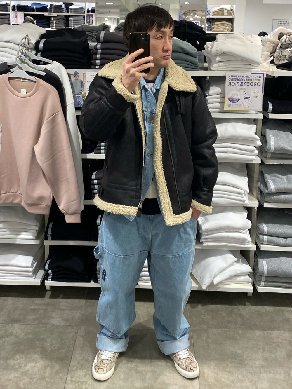 ブラック系のその他アウター、ブルー系のその他パンツ、その他のスニーカーを着用したメンズの冬コーディネートの3枚目の写真