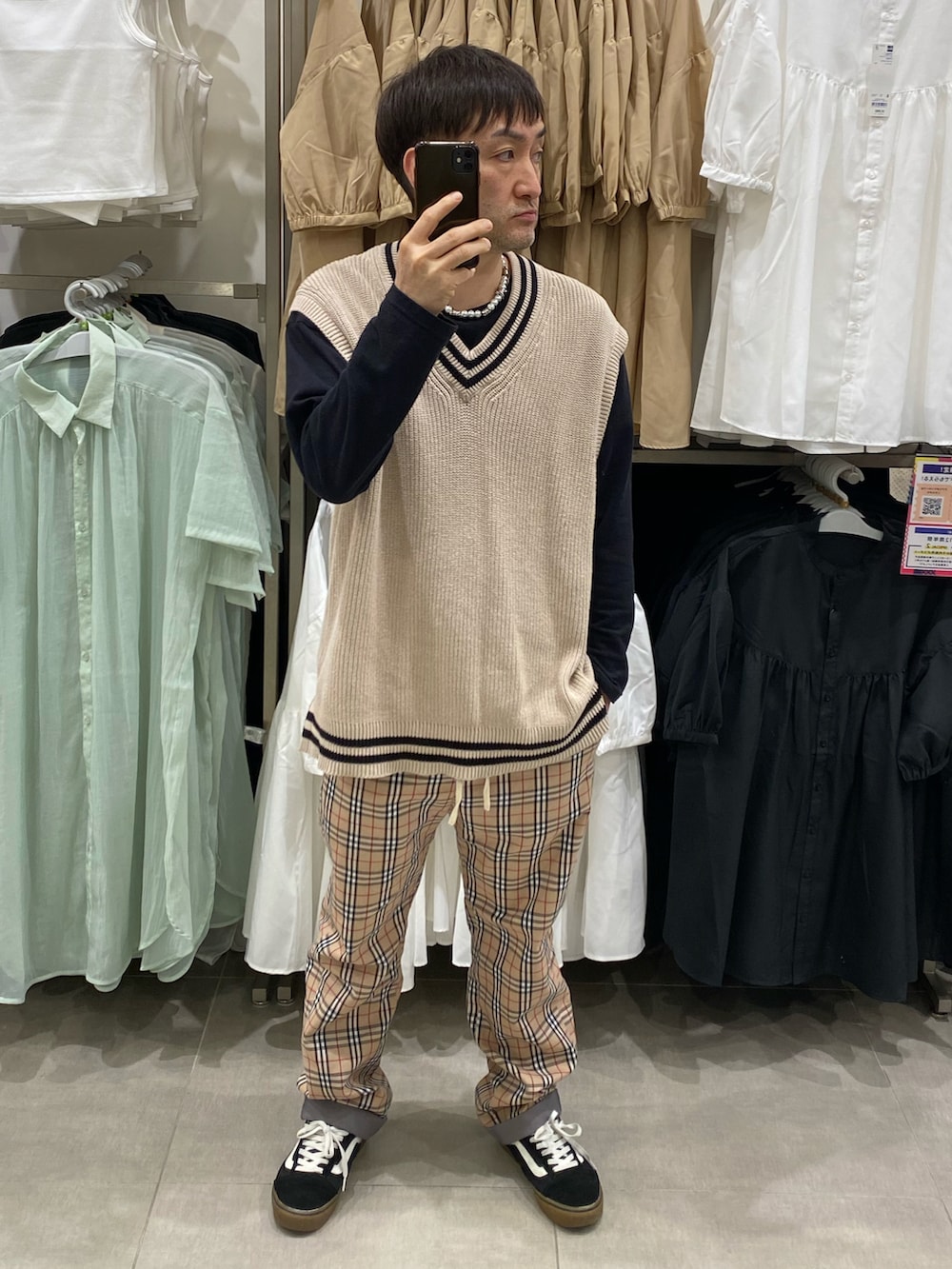 ベージュ系のベスト、ベージュ系のパンツ、ブラック系のスニーカーを着用したメンズの春コーディネートの3枚目の写真