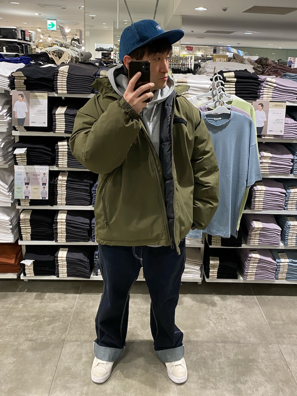 ホワイト系のスニーカー、ブルー系のカーゴパンツ、グリーン系のブルゾンを着用したメンズの冬コーディネートの3枚目の写真